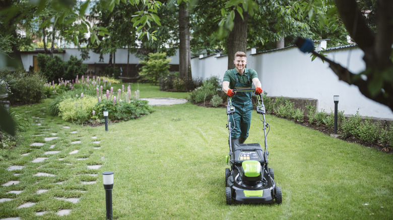 Worker mows lawn