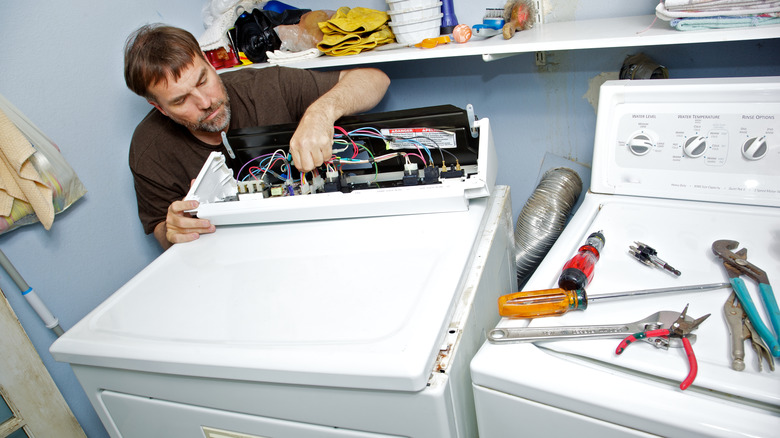 Homeowner pulling wires from dryer