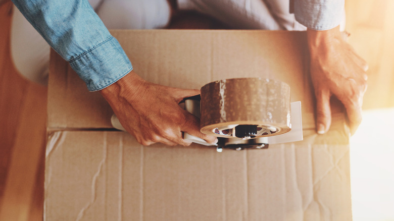 Sealing a cardboard box closed with tape