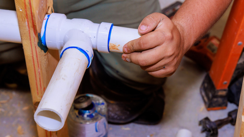 A man trying to remove a glued PVC fitting