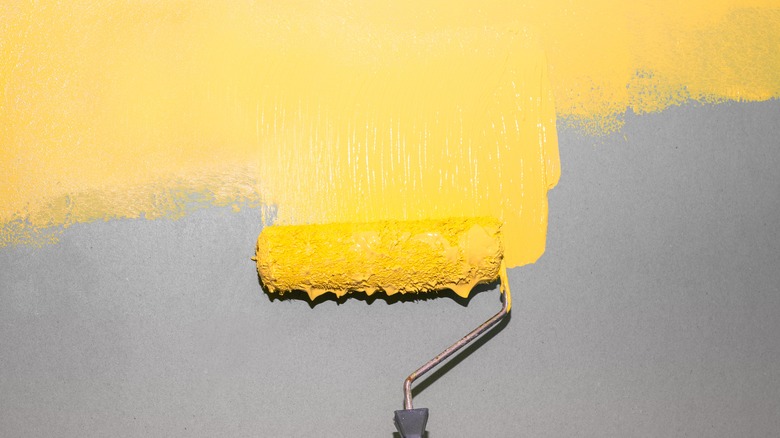 Dripping paint roller on wall