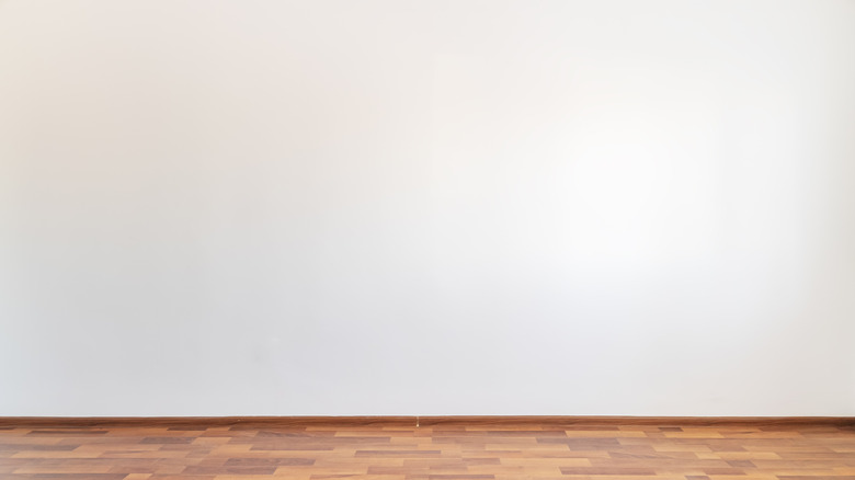 Empty room painted white with brown floor