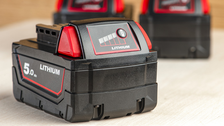 A lithium-ion battery for a power tool sitting on a work bench