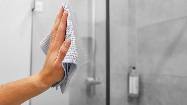 Hand using towel to dry shower