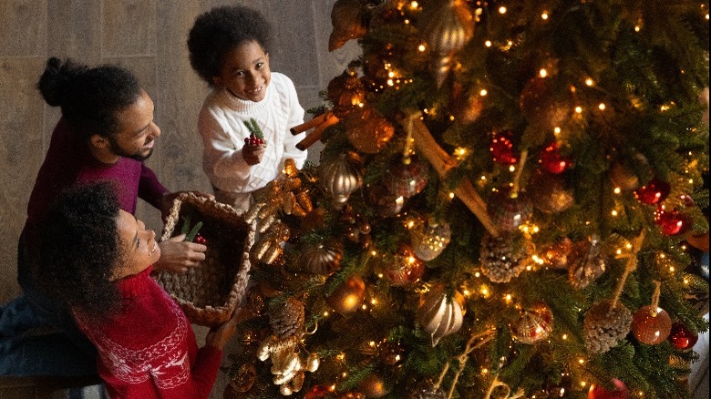 family decorating Christmas tree