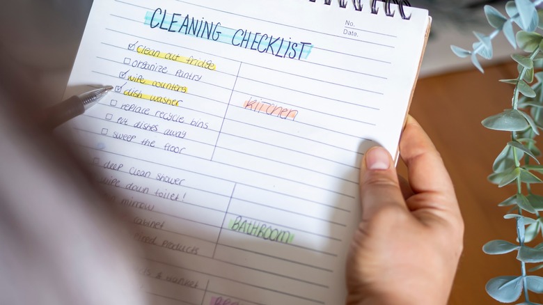 person holding cleaning checklist 