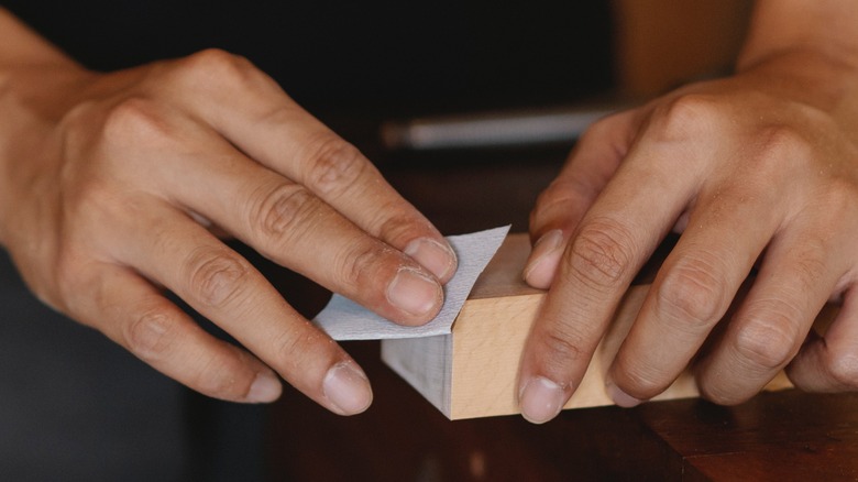 Person using sandpaper on wood