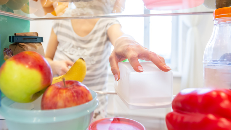 Woman reaching for plastic container