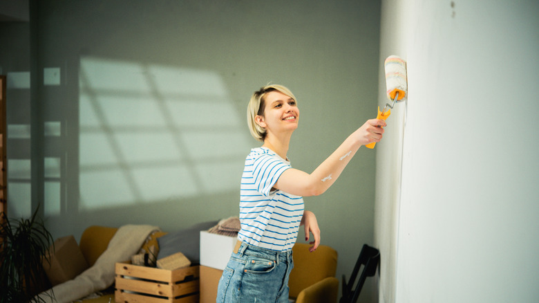 Woman using roller to paint