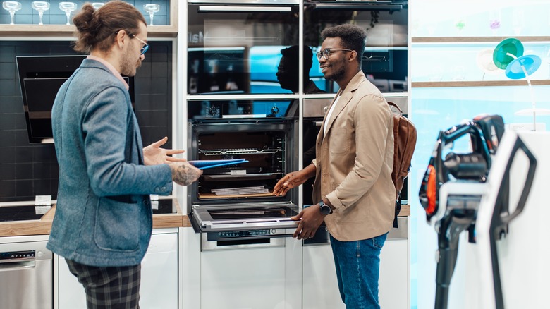 man buying oven in store