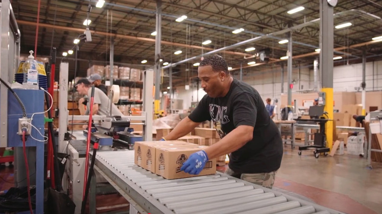 Gloved workers packaging and labeling boxes of Gorilla Glue in the company's Cincinnati factory