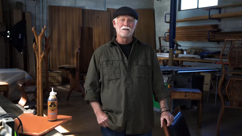 Gorilla Glue inventor Mark Singer stands in his woodworking shop next to a bottle of Gorilla Glue