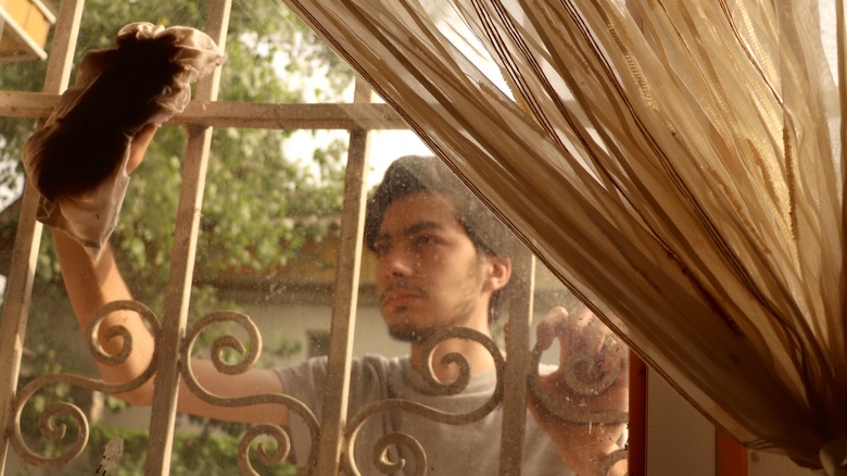 young man cleaning window