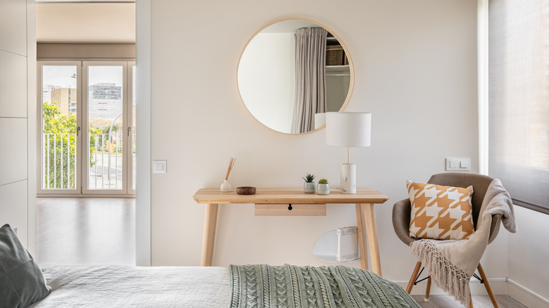 Scandinavian modern bedroom with desk, mirror, and chair