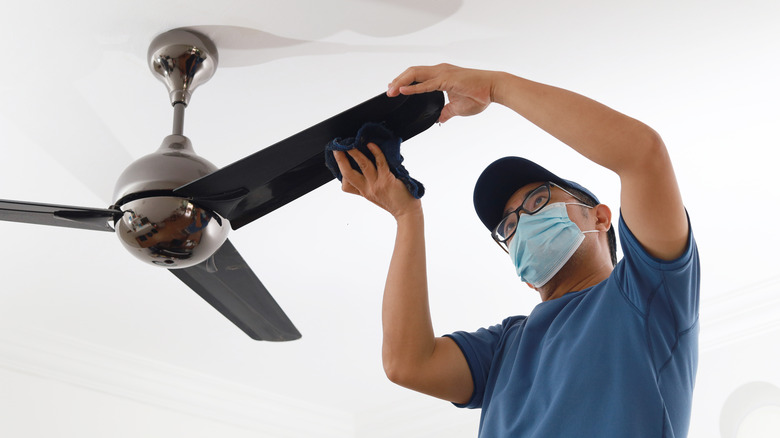 man cleaning ceiling fan