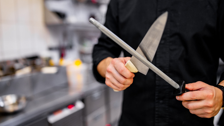 Person sharpening knife with steel