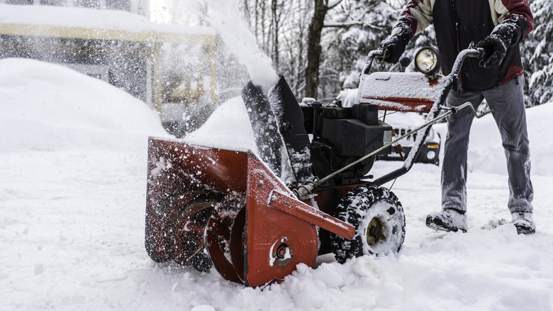 Person uses snow blower outside