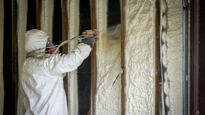 Professional adding spray foam insulation inside wall