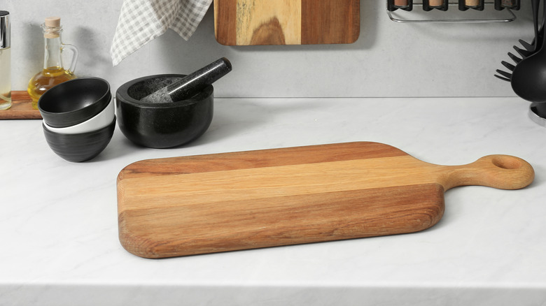 Wooden cutting board on top of a countertop.