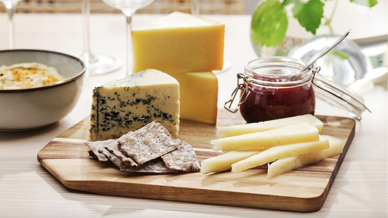 IKEA SMAATA cutting board with various cheeses, crackers, and jam.