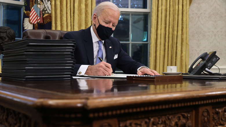 Joe Biden writing on Resolute Desk