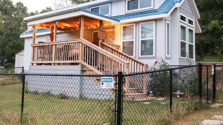 House enclosed by black chain link fence