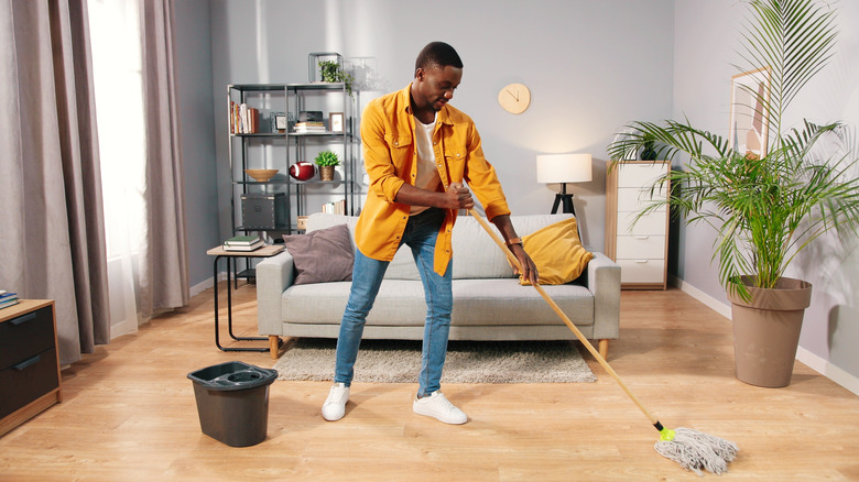 man mopping hardwood floor