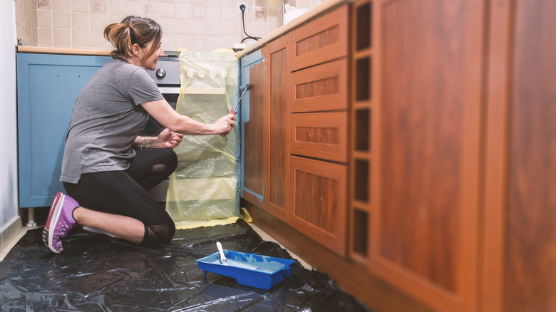 Woman paints cabinets blue