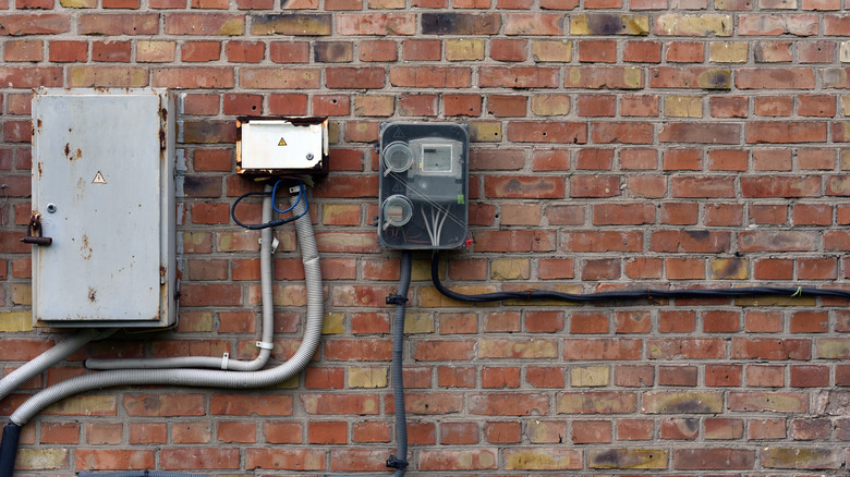 A breaker box that is rusted on exterior brick wall