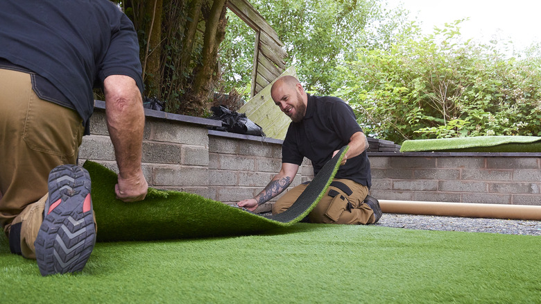 Workers installing artificial grass