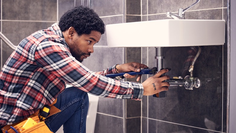 Plumber checking bathroom sink drain