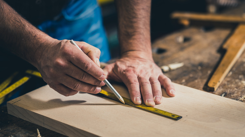 hands making woodworking measurements