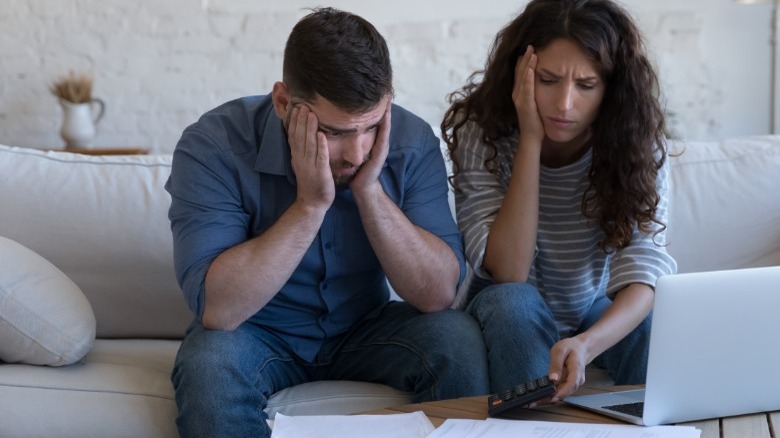 Frustrated couple at table with laptop