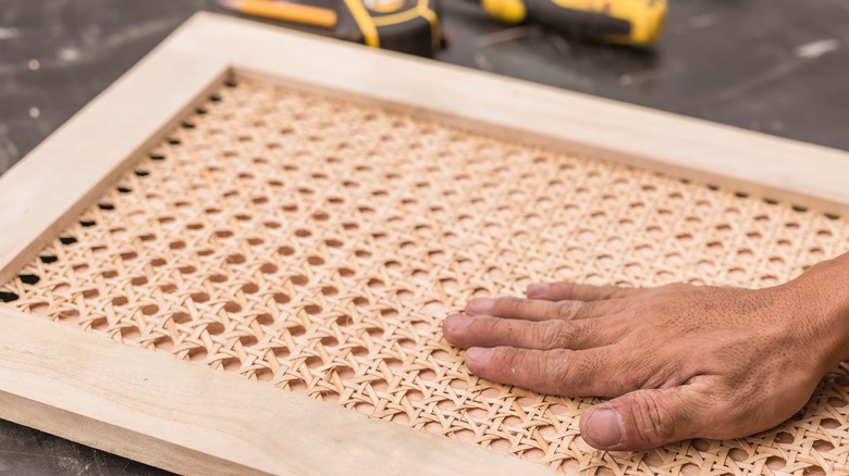 man making cane cabinets