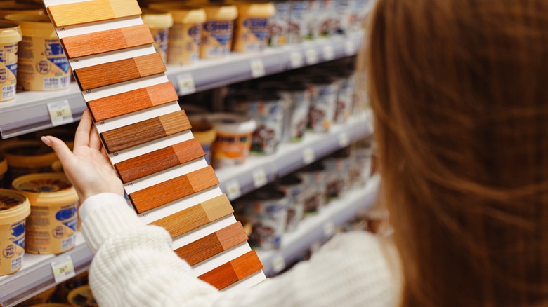 woman holding wood stain samples