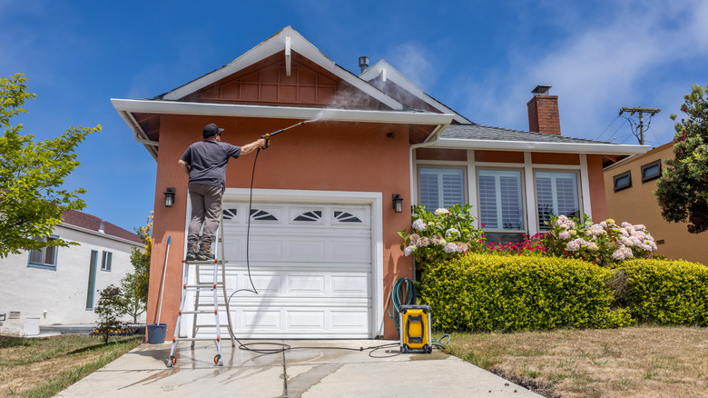 man spraying house eaves