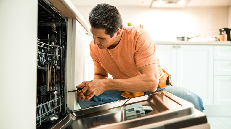 man looking inside dishwasher