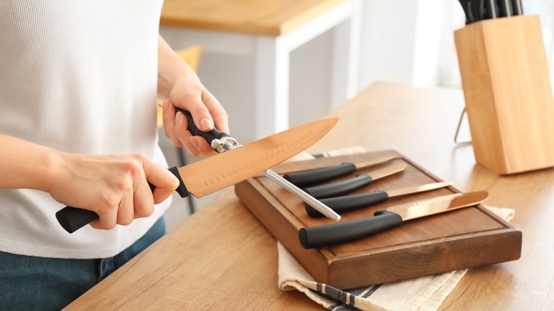 person sharpening knives 