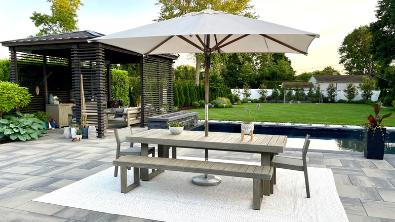 Nice modern backyard space with large table and umbrella