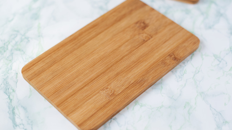 Bamboo cutting board with rounded corners on marble surface