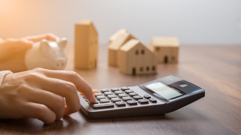 Hands with calculator and houses