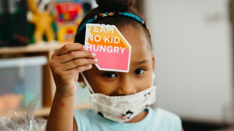 Kid holding No Kid Hungry sign