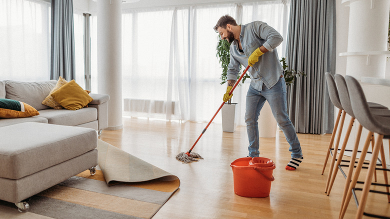 Man using bucket to mop