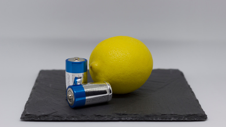 A lemon beside batteries