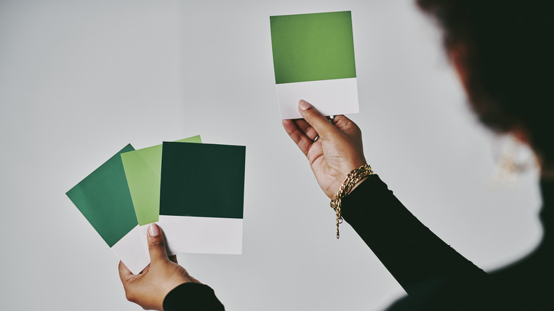 Woman holding green paint samples
