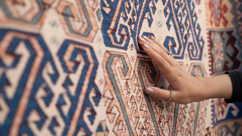 woman touching a silk rug