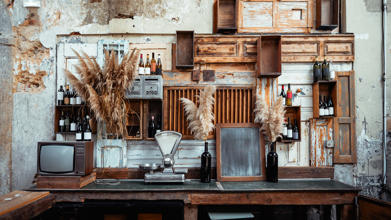 A wall filled with antique decor, like mirrors, wood panels, and a TV.