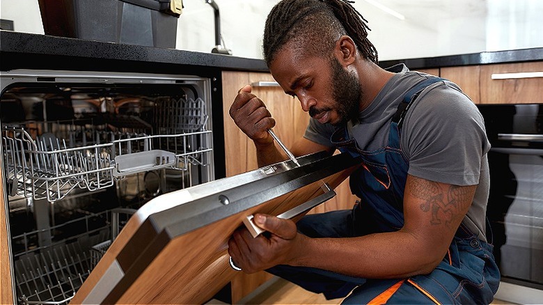 Person installing dishwasher panel