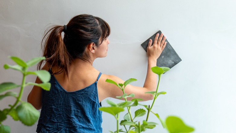 Woman sanding walls