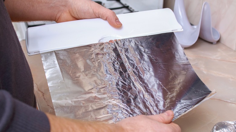 hands tearing piece of foil